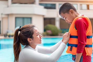 Mother adjusting a lifejacket on her son